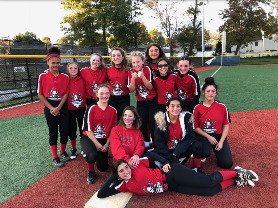 LADY WARRIORS: The softball team poses in front of the field they played at.