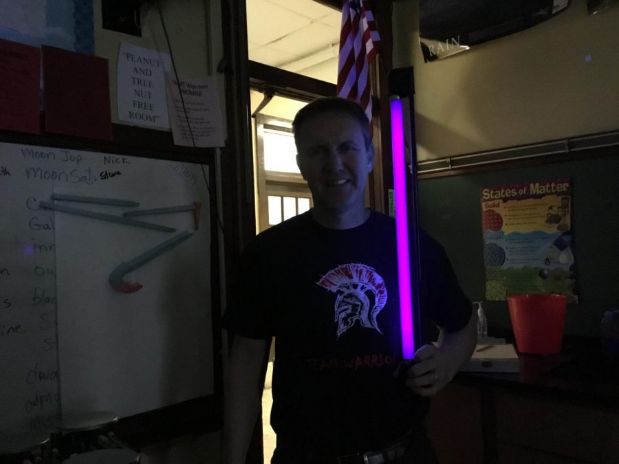 Mr. Blackmore holding  UV light in the dark. 