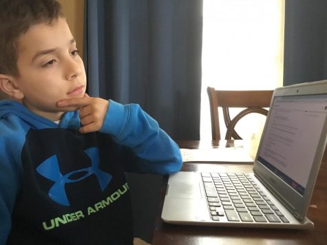 Younger brother of WMS student concentrating on distant learning school work.