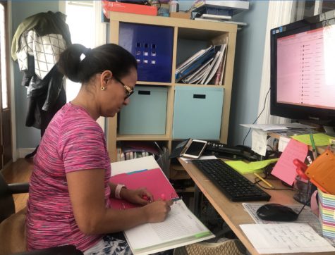 Patrica Rodriguez, a Spanish teacher, grading her student work while practicing social distancing.