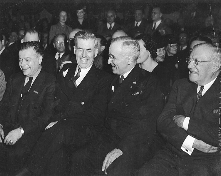 Photo Via: https://commons.wikimedia.org/wiki/File:Group_of_men,_including_David_Dubinsky_and_Harry_Truman,_conversing_and_laughing_in_a_crowded_room_%285279148229%29.jpg. Under the Creative Commons License. 