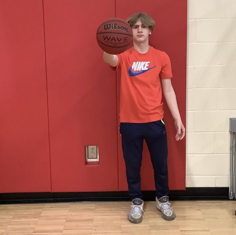 MARCH MADNESS: 7th grade student holding up a basketball thinking about his bracket.