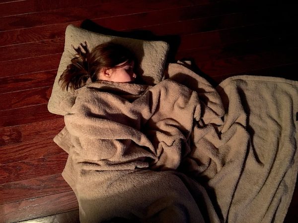 A kid sleeping on the floor while having nightmares 
Photo from https://www.pickpik.com/sleep-pillow-sleepwalking-portrait-photography-beautiful-52002 
under Creative commons license