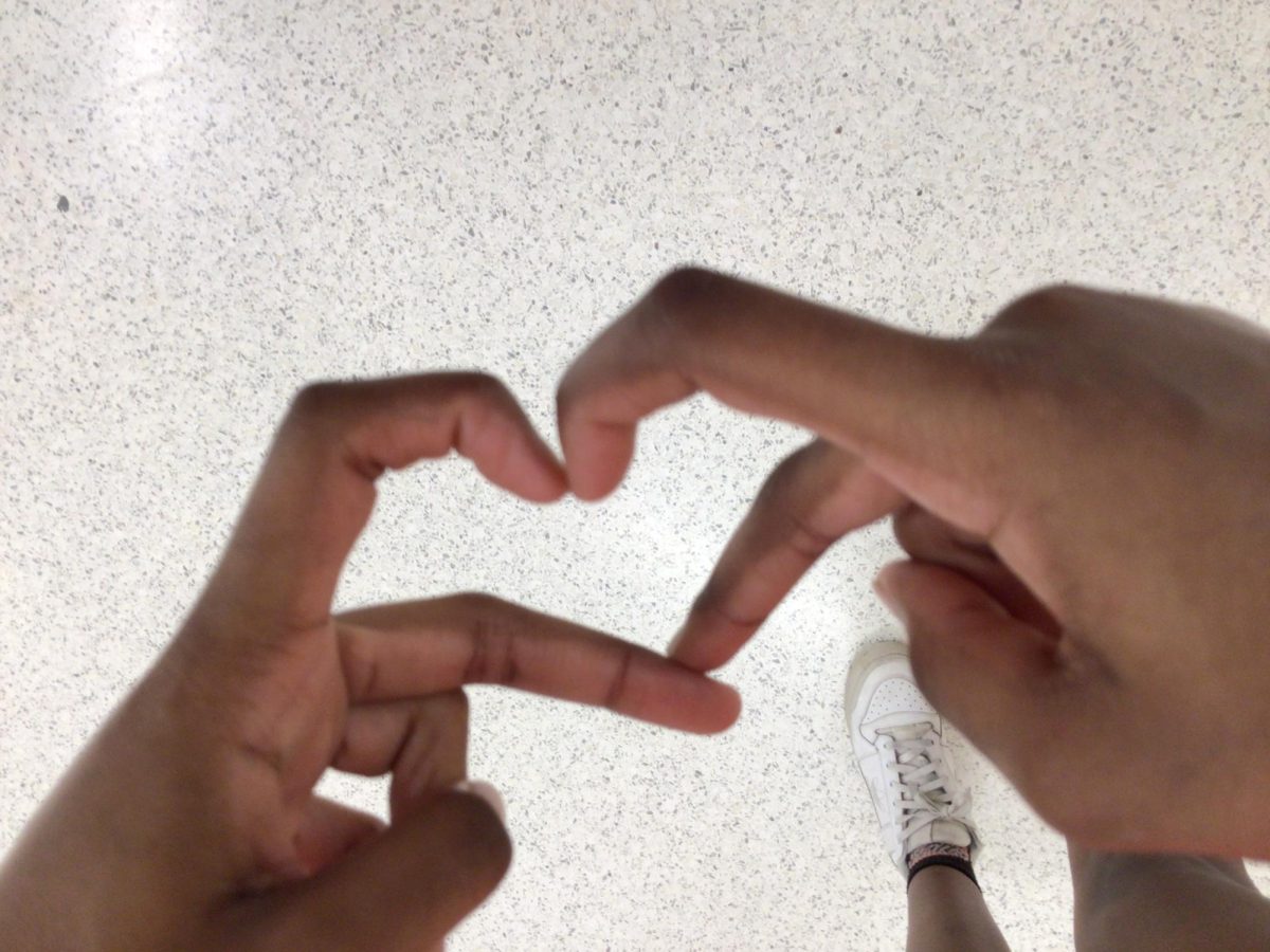 Brielle Nelson makes a heart with her hands.