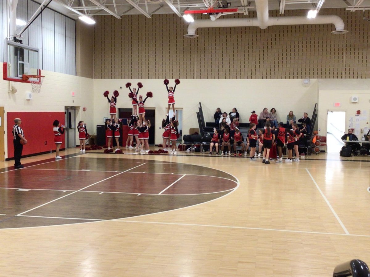 Cheerleaders go into a stunt at the girls basketball game.
