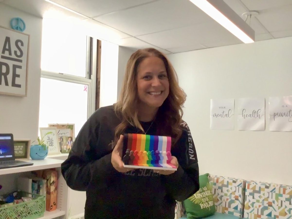 Caption: Mrs. Acheson holds Legos representing a rainbow in her office. 