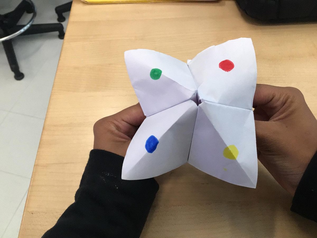 Alyssa holding a finished paper fortune teller. 