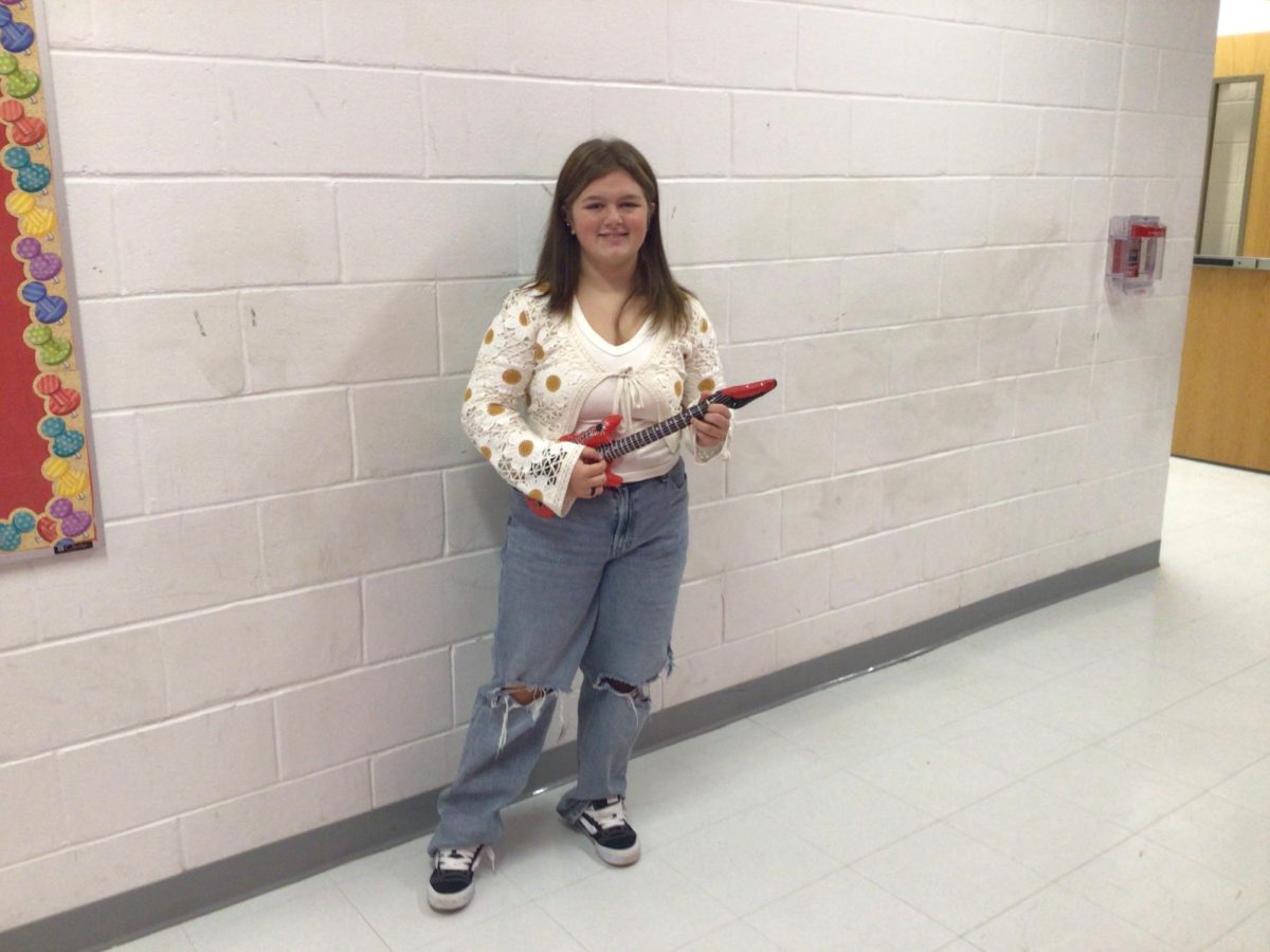 Kali Locacio holds a guitar at WMS