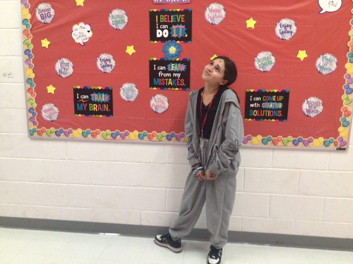 WMS student poses infront of a inspirational board. Everybody is going through their own struggles so don't try to put more weight on their shoulders.