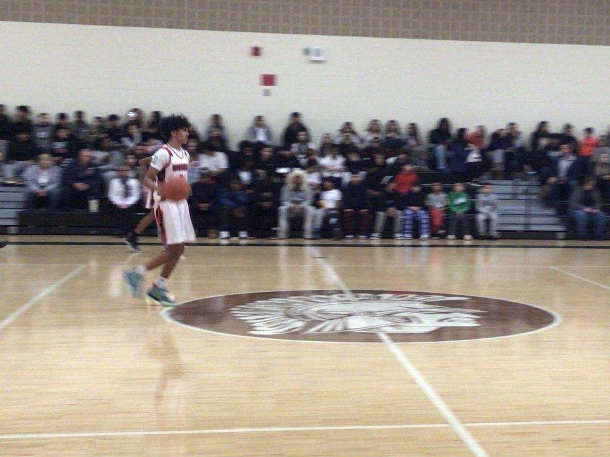 Caiden Pinto runs the ball down the court on December 5th during the white out game