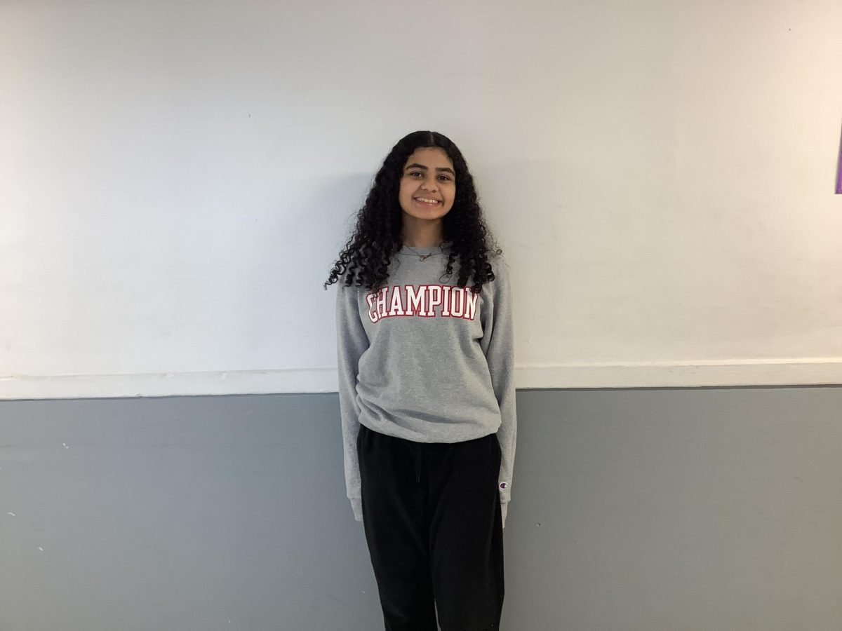 Janiah Malik poses for a picture outside the auditorium in 4th period.