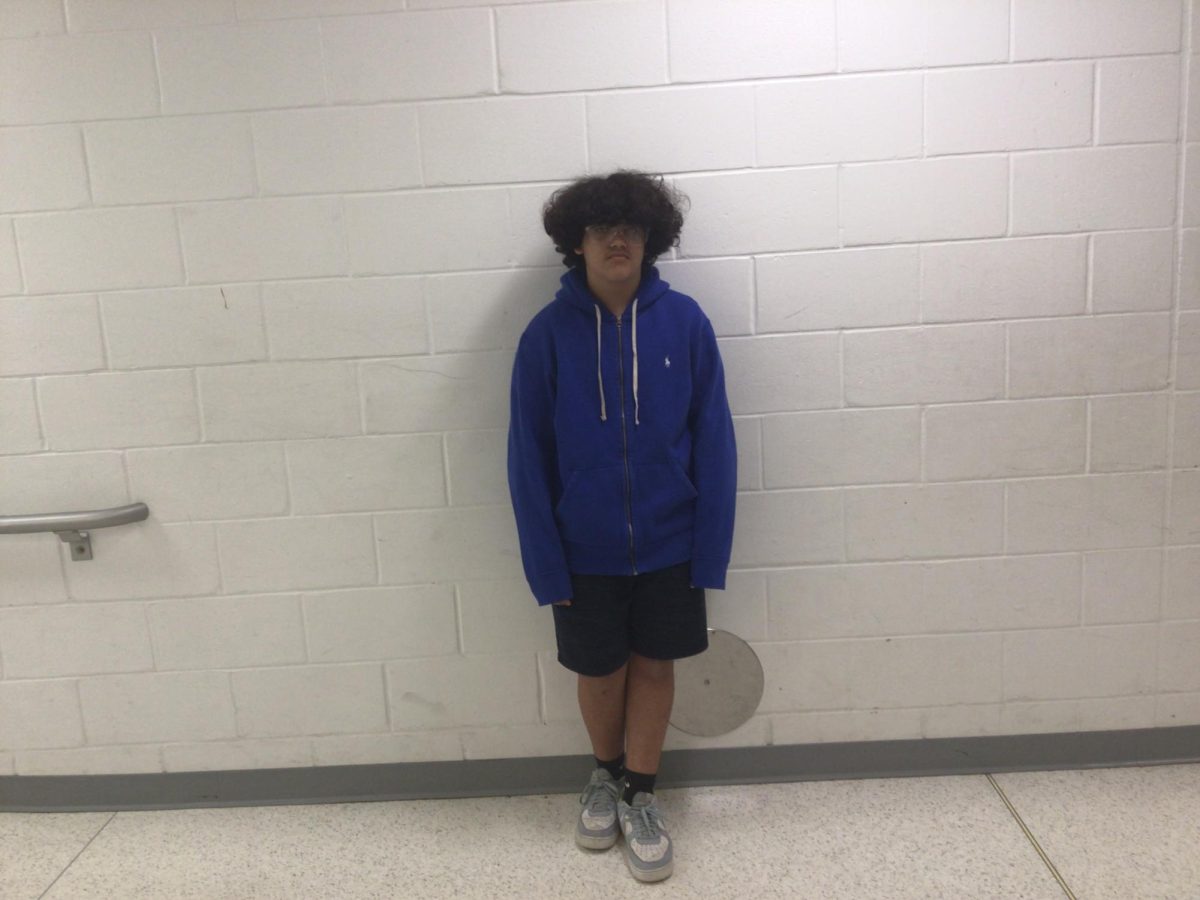 William Cruz poses for picture in the art room hallway
