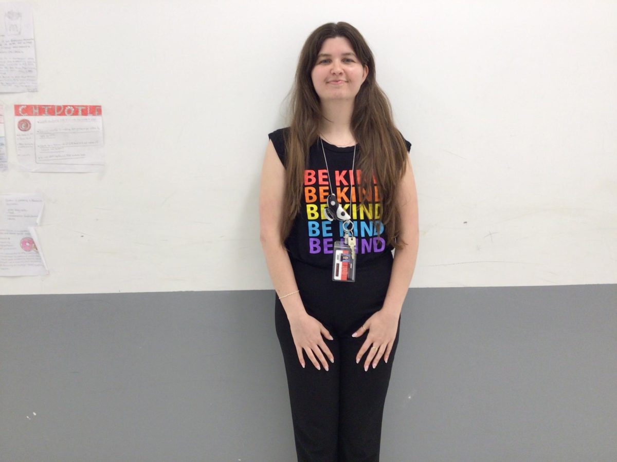 Ms. Desch poses for photo in front of room 319