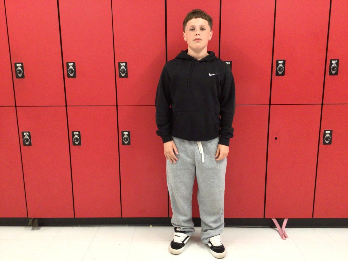 Elliott-Cardet-Merrill poses for photo in front of room 308.