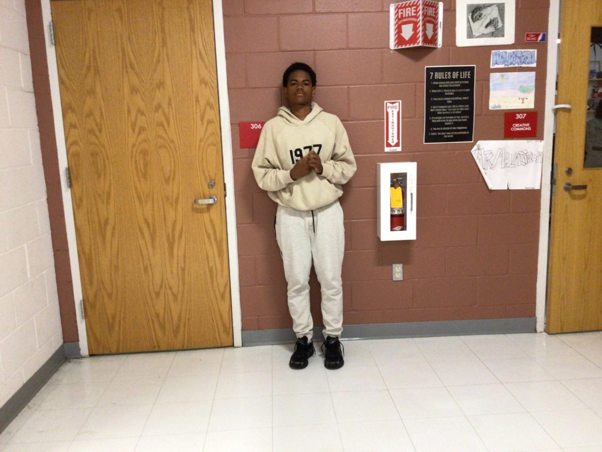 Bryce Arnold poses for photo in front of room 308