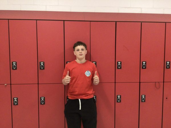 Elliot- Cardet- Merrill poses for photo in front of room 308