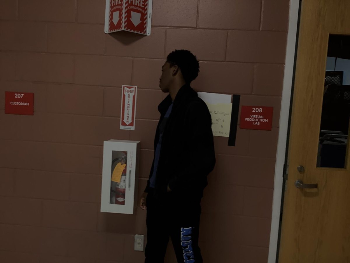 Jaylin poses for a photo in front of room 208