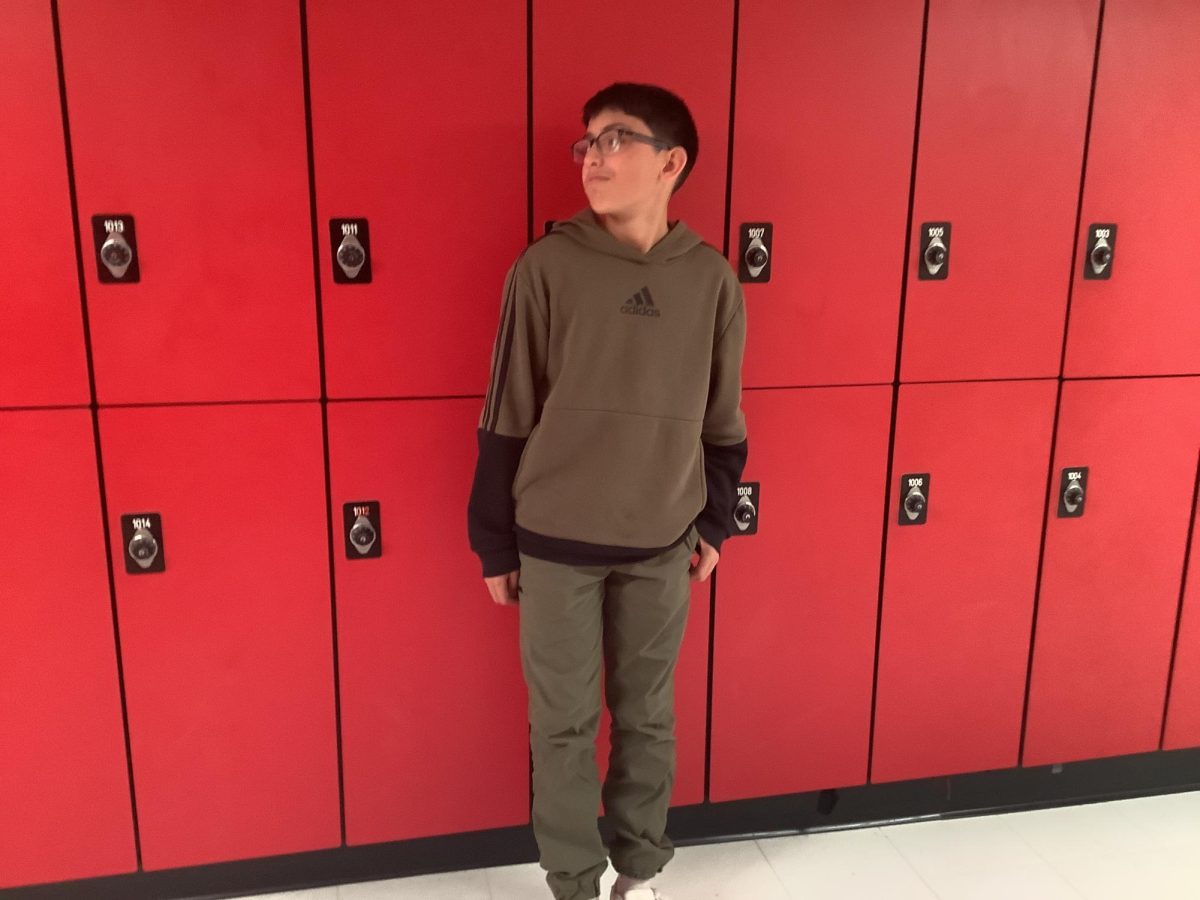 Eli Hercules poses for a picture outside of room  100.