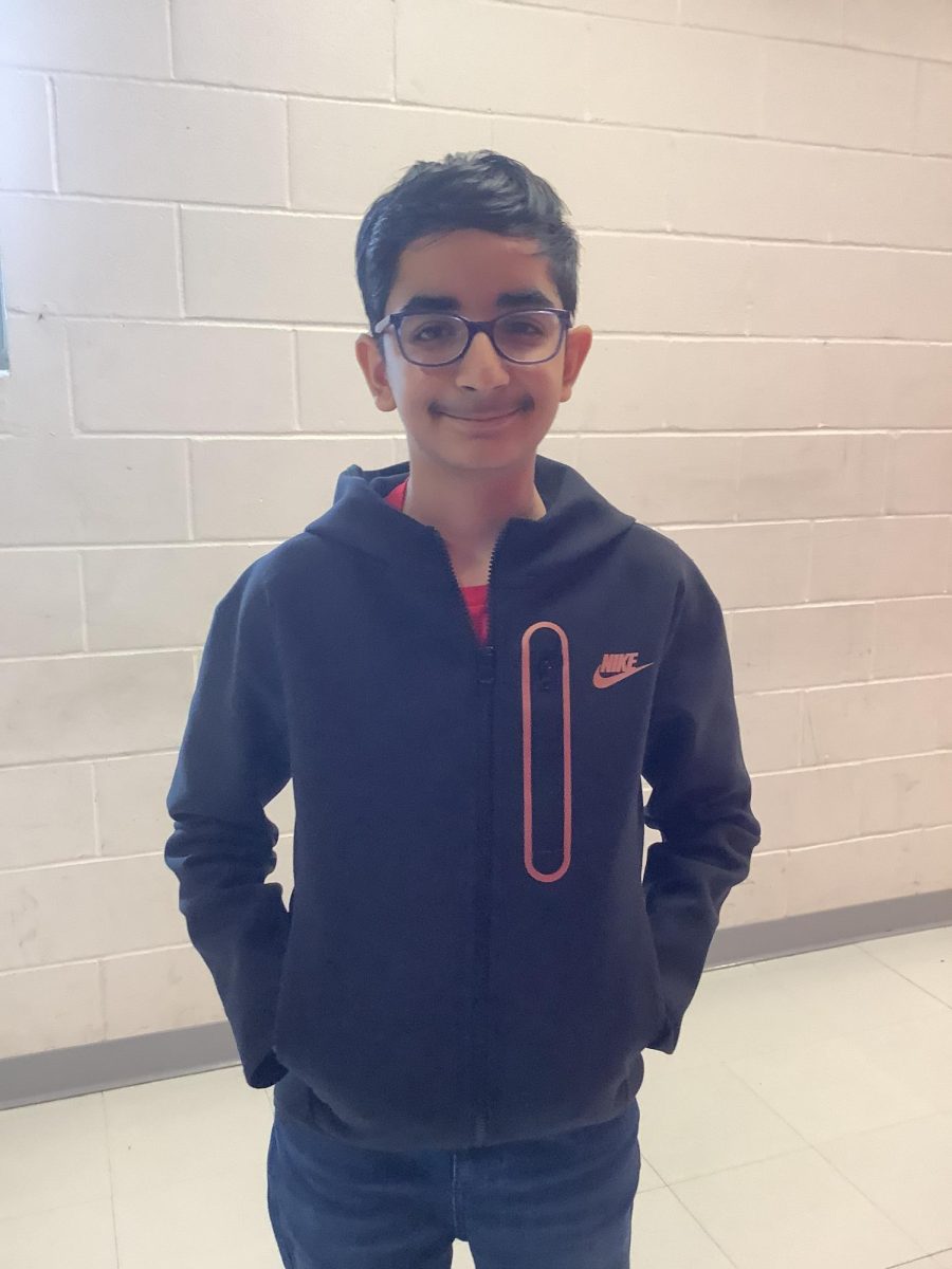 Rohan Mehandirata stands in the middle of the hallway in front of Mr. Guidetti's classroom
