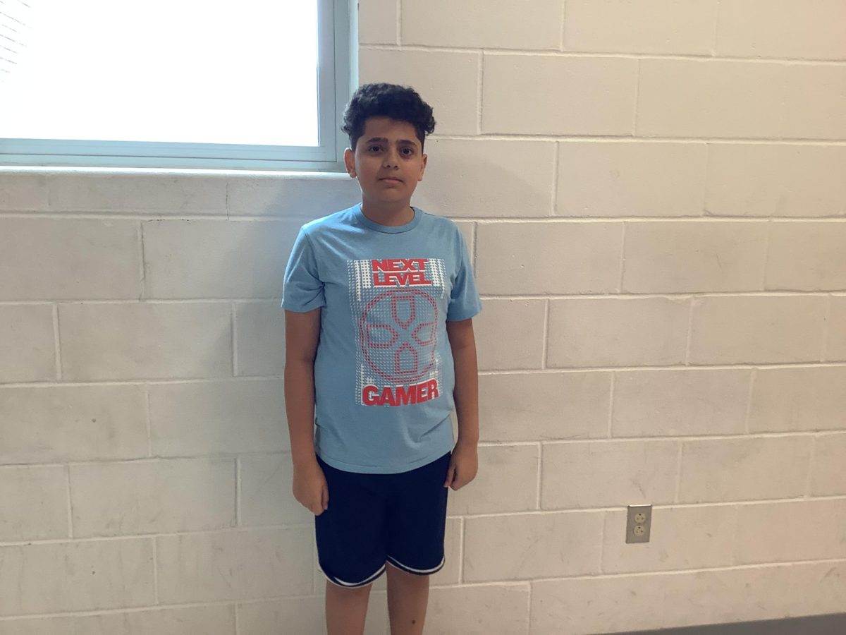 Yaseen Alnashar poses by a window in the hallway by Mr. Guidetti's 4th period class on a Friday at WMS