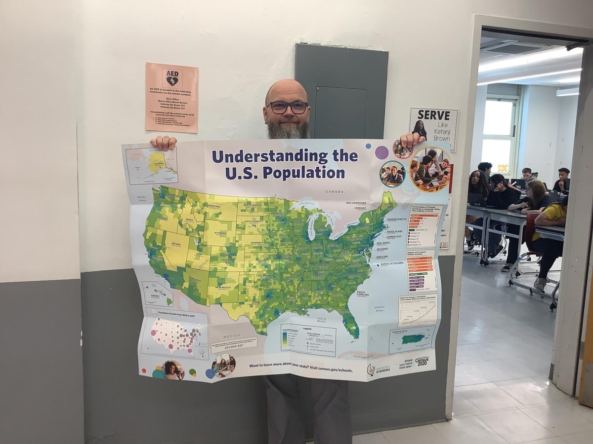 Mr. Miller holds up a map of the USA