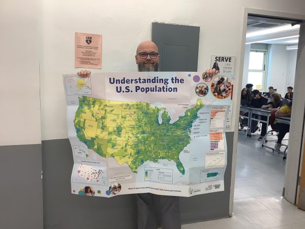 Mr. Miller holds up a map of the USA