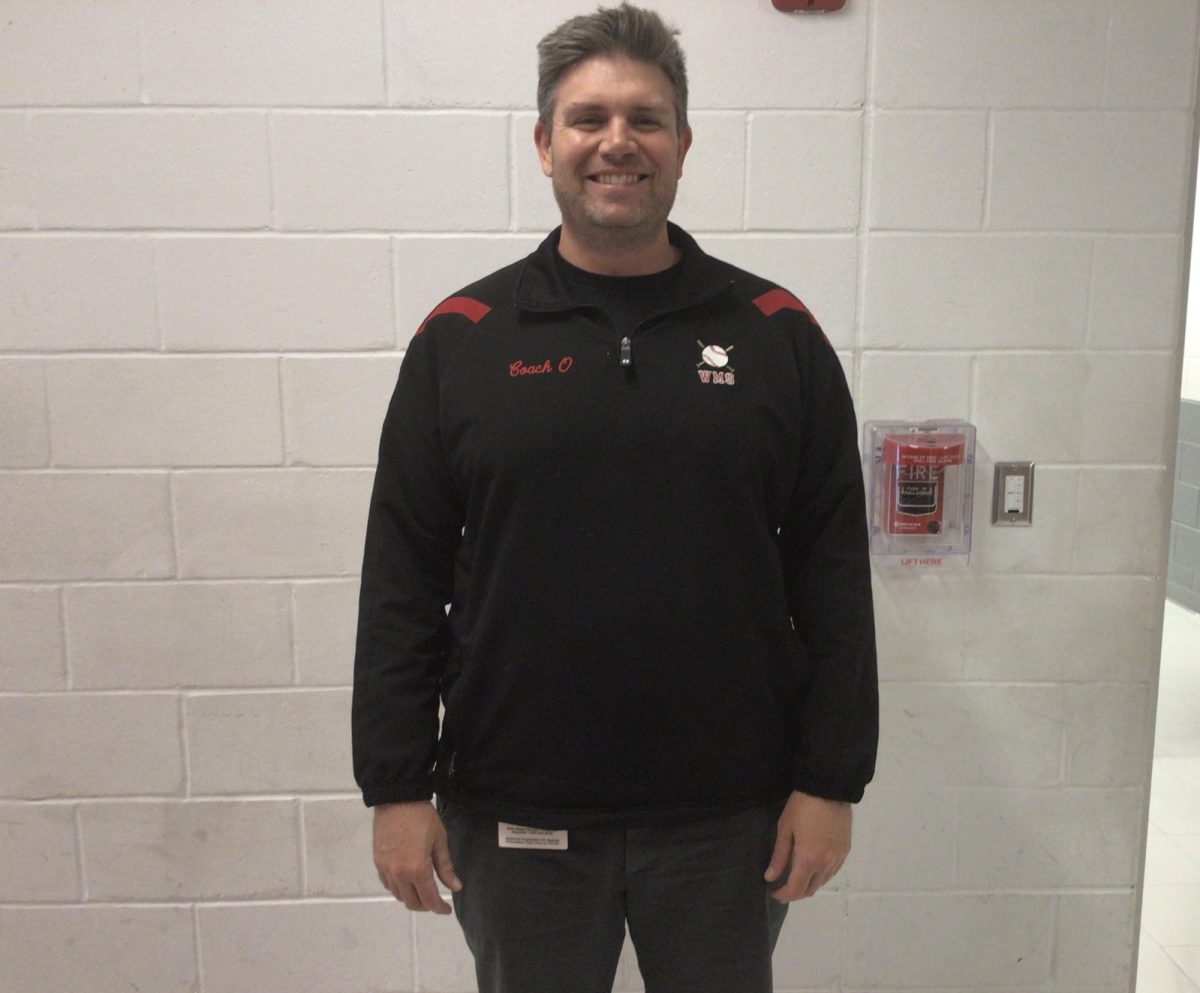 Mr. Olvesen poses in the hall by his class at WMS.