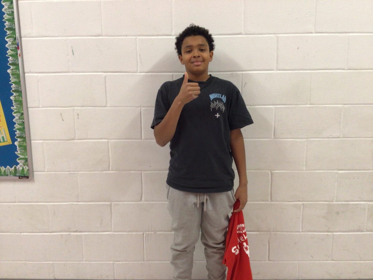 8th grader Kai Dowell poses in front of room 308