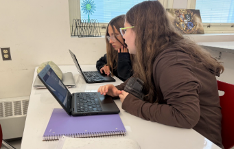 Students collaborate on their laptops in language arts, showing how artificial intelligence and technology is quickly shaping the way our schools teach and learn today. 