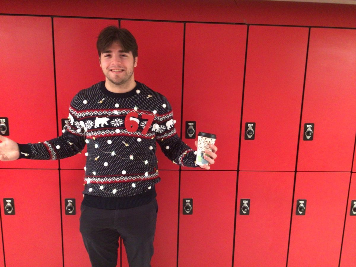 Mr Godkin poses using his 67 sweater on ugly sweater day at WMS.