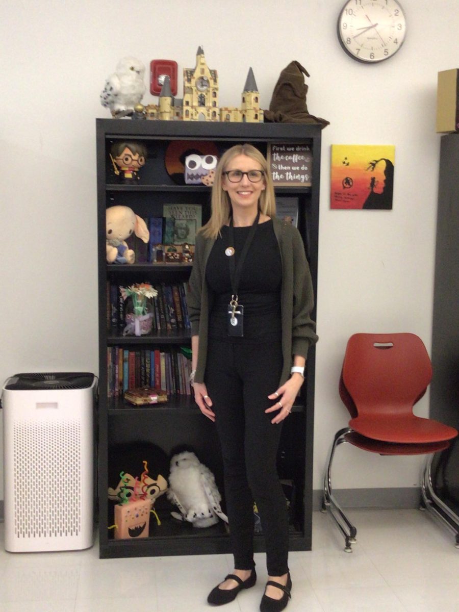 Mrs. Douglas stands by her book shelf in her classroom.