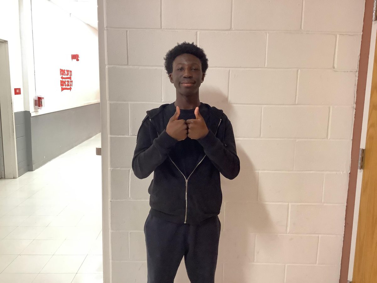 Elijah Richards poses outside room 308 for a picture
