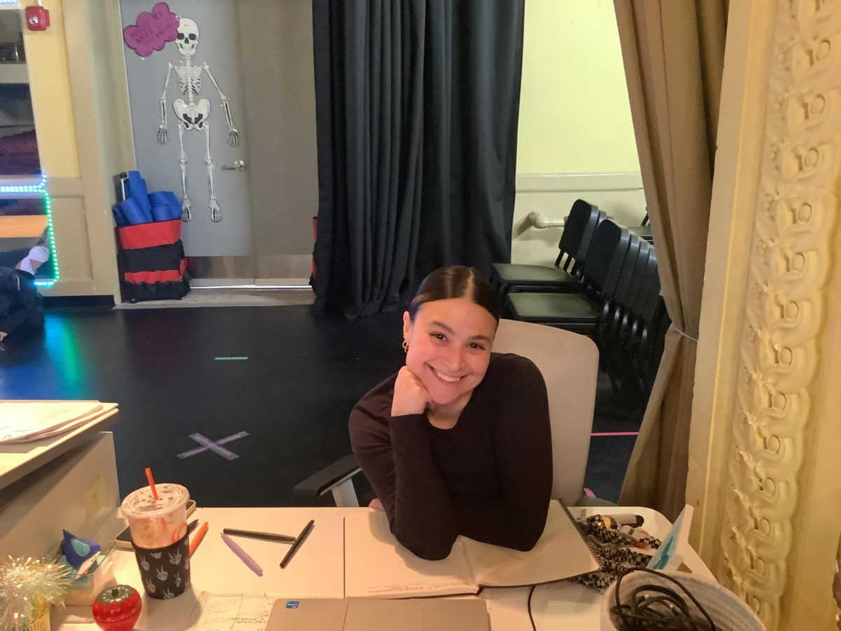 Ms. Carreli Smiles at her desk during an interview