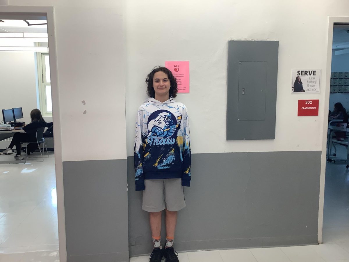 mason wicinski leans up against a wall