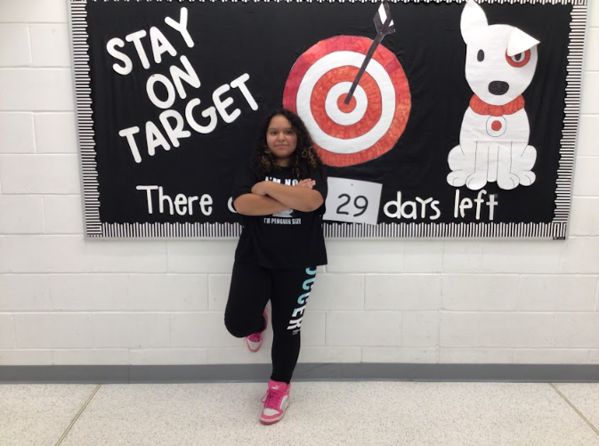 Adalee Gonzalez poses infront of a bulletin board.
