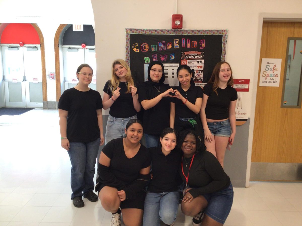  Crismarie Perigo,Alyssa Linko, Amina Lone, Amelia Carrero Nunez, Gabriella Ayala, Emily Zielinski, Chloe Jencik and Cayarra Rahim pose outside of Mrs. Valente's office dressed as Darrell Curtis from The Outsiders 

